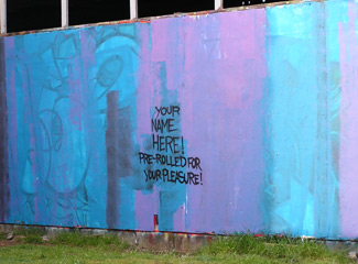 the graffiti wall on the river front (it says 'your name here! prerolled for your pleasure!': photo by Sienna